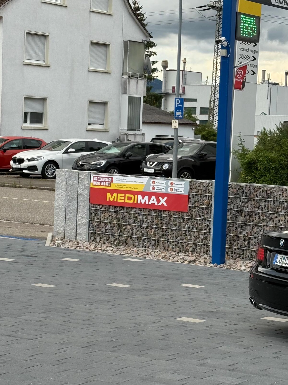 Probst Carwash GmbH - Autowaschanlage mit Bistro - Ein Automechaniker in einer Autowerkstatt überprüft den Motor.